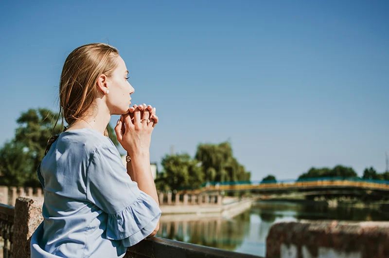 christian-counselling-australia-online-phone-reflective-woman-praying Woman praying by a river considering online Christian counselling in Australia