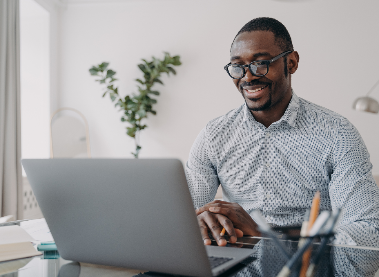 eap-counselling-online-phone-australia-employee-laptop Man smiling while using laptop for online EAP counselling session across Australia, available in English and Spanish