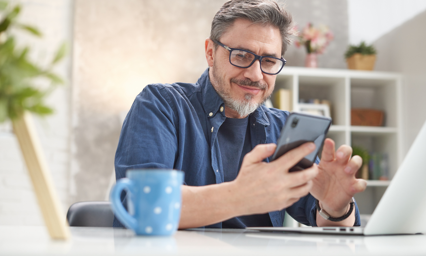 contact-counselling-supervision-enquiry-australia Man smiling while holding a phone, ready to contact counselling services in Australia